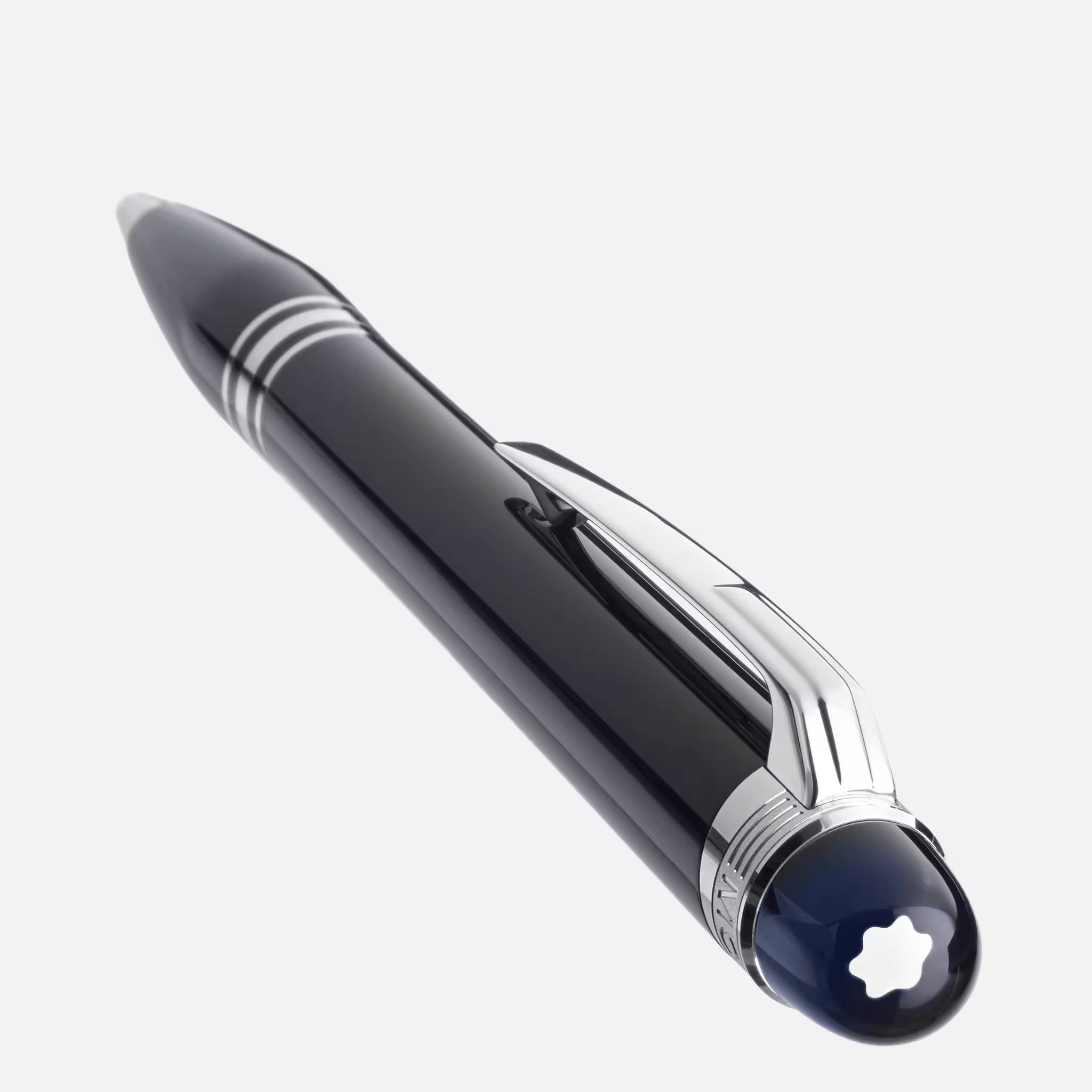 Penna a sfera Montblanc StarWalker nera con finiture platino, tre anelli e cupoletta blu con emblema bianco, distesa su fondo chiaro