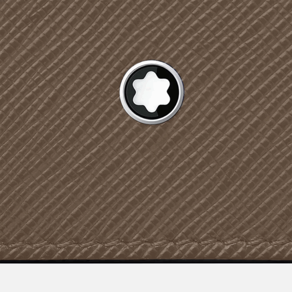 Dettaglio dell’emblema Montblanc su pelle saffiano color Mastic, con texture visibile in primo piano