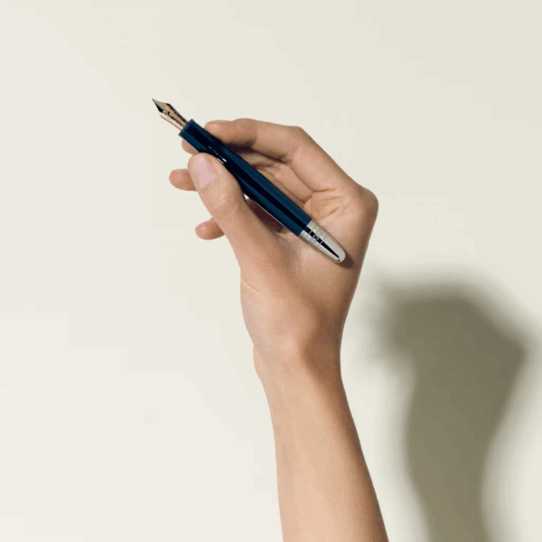 Mano che impugna una stilografica Montblanc blu con finiture argento