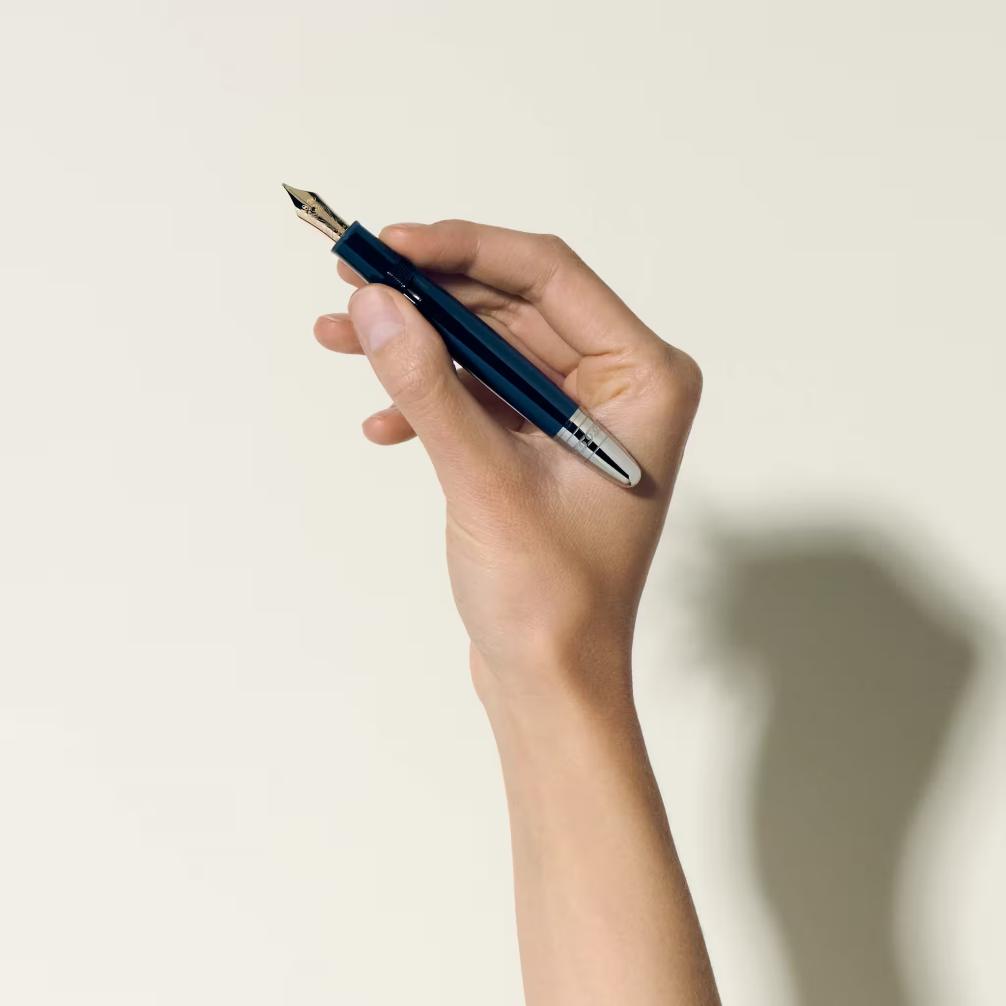Mano che impugna una stilografica Montblanc blu con finiture argento