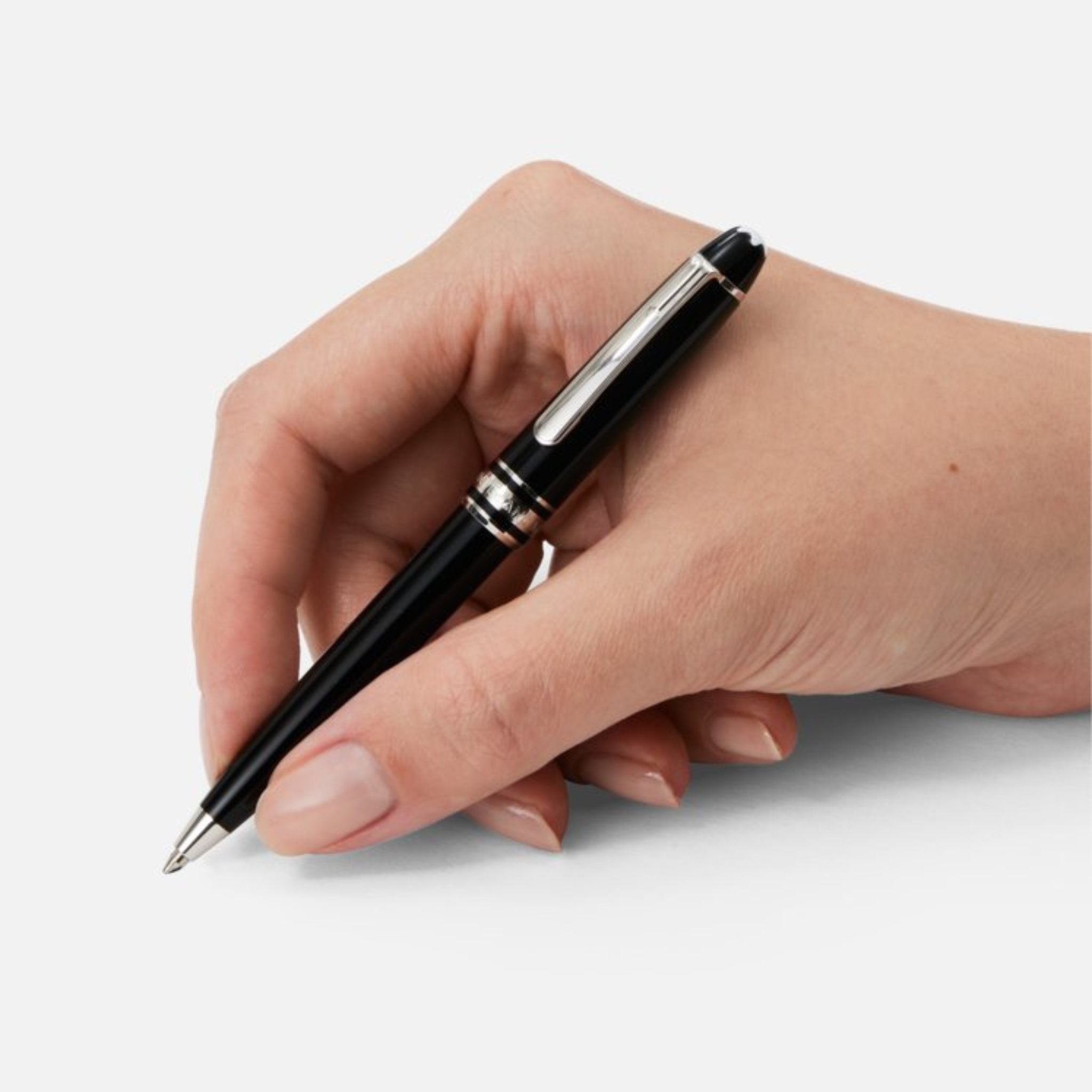 Penna a sfera Montblanc Meisterstück Mozart in resina nera con finiture platino, impugnata da una mano pronta a scrivere