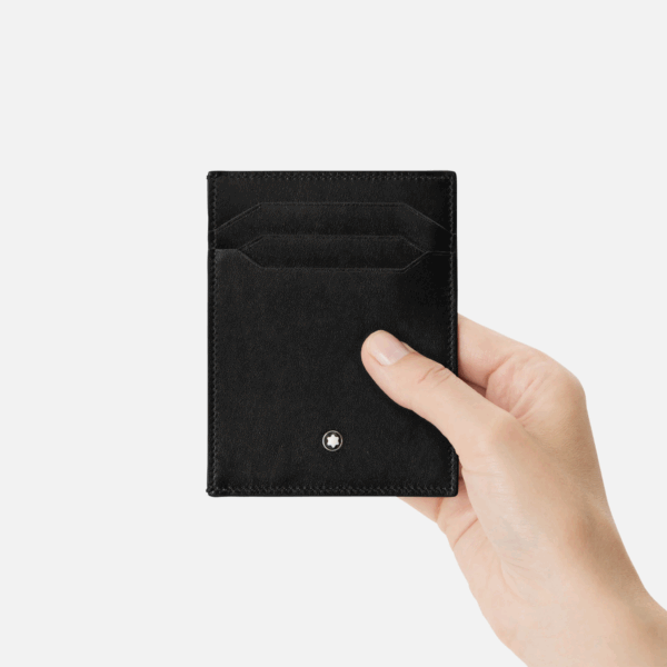 Portafoglio Montblanc in pelle nera tenuto in mano con emblema metallico frontale