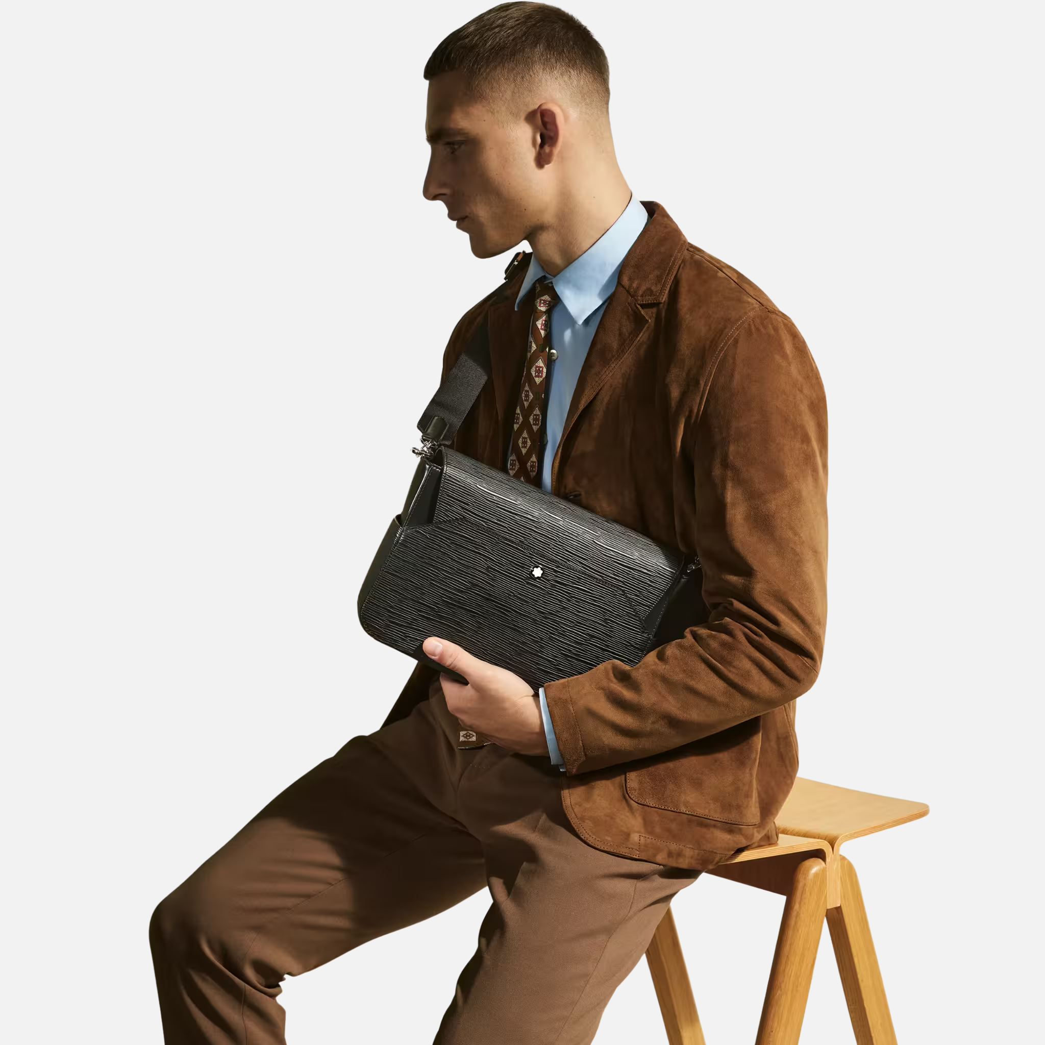 Messenger Bag 4810 Montblanc – Eleganza compatta in pelle corteccia Messenger Bag 4810 Montblanc in pelle nera con motivo corteccia indossata con outfit elegante