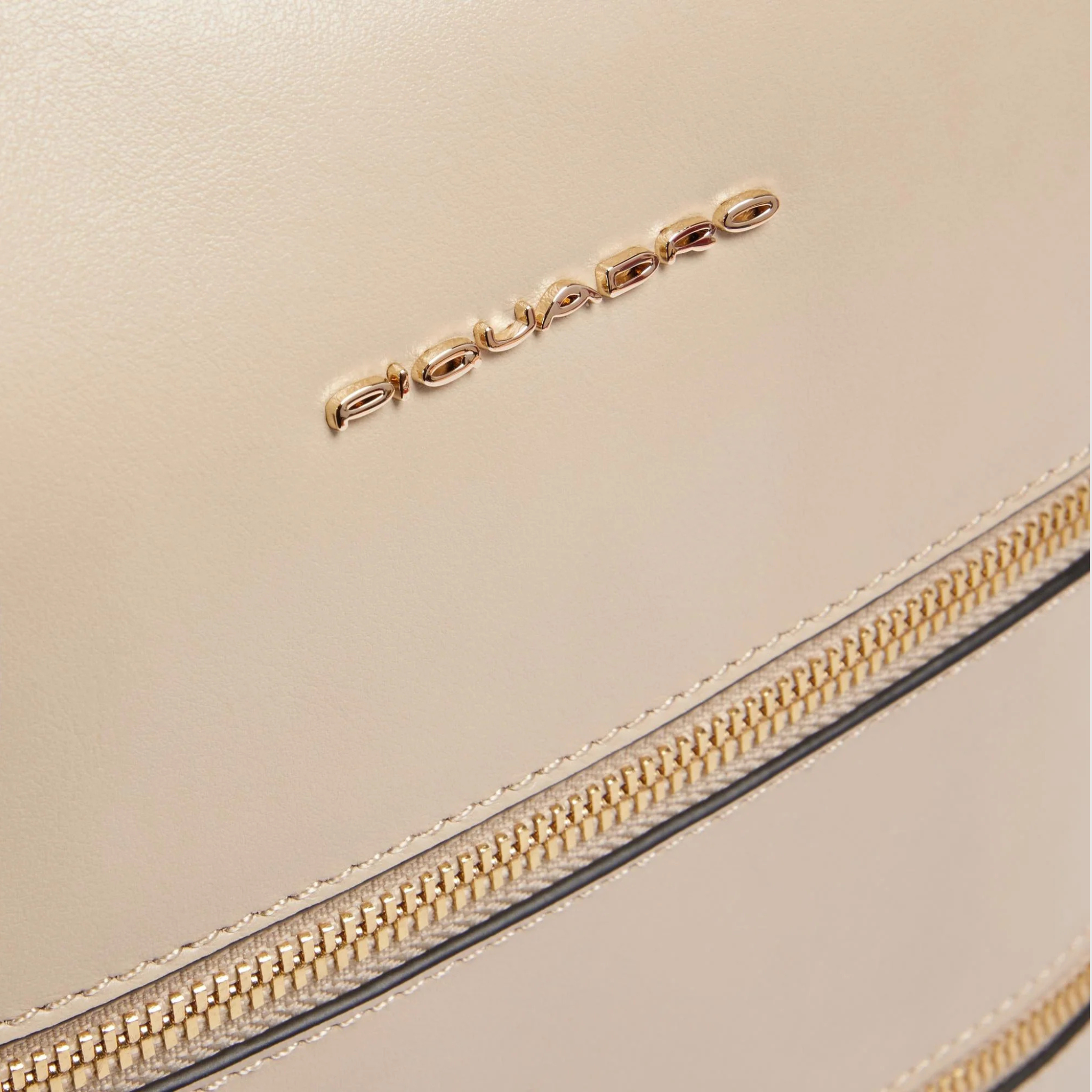 Dettaglio logo Piquadro e zip dorate su pelle beige